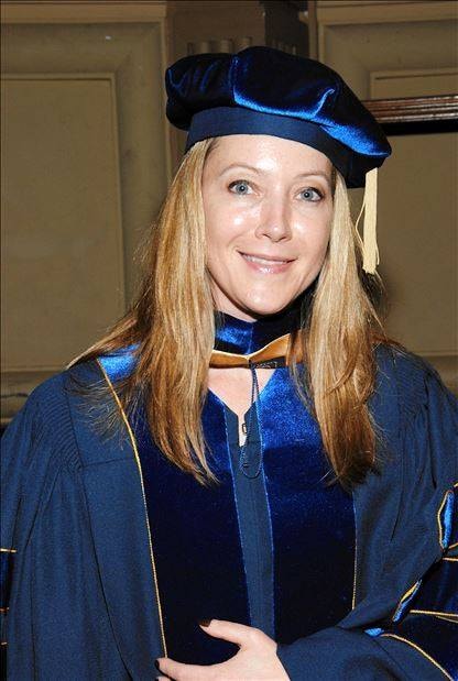 College advisor with student in graduation regalia